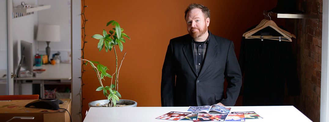 Brian Wyrick standing in front of a pile of Henchmen comics