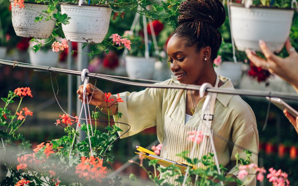 Woman with hanging plants in her nursery