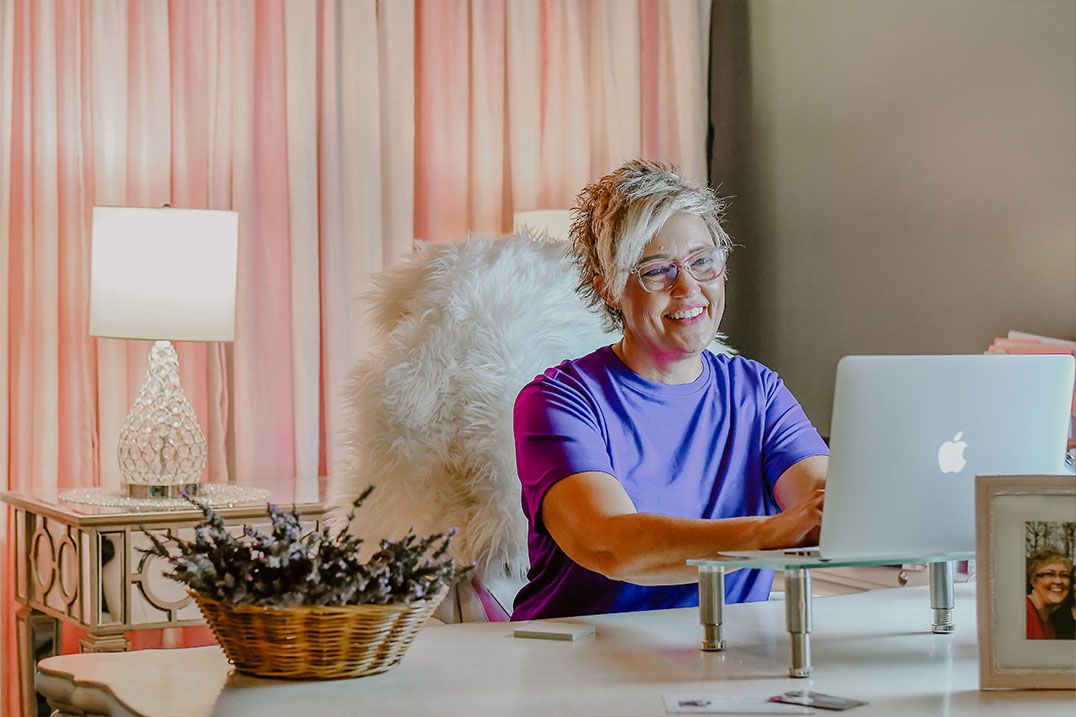 Stacie Overman working at a computer in her home office.