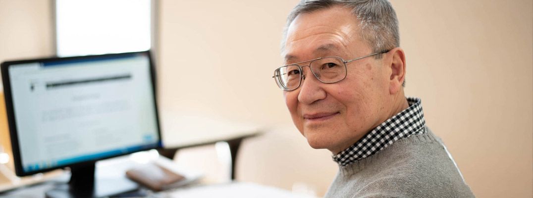 Lane Community College business instructor Roger Wong at his computer